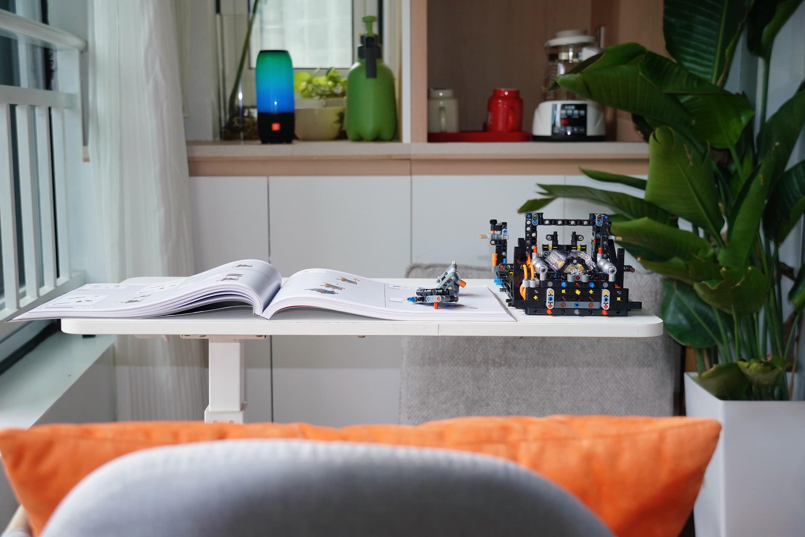 Mid-build engine bay subassembly with open manual on a white side table