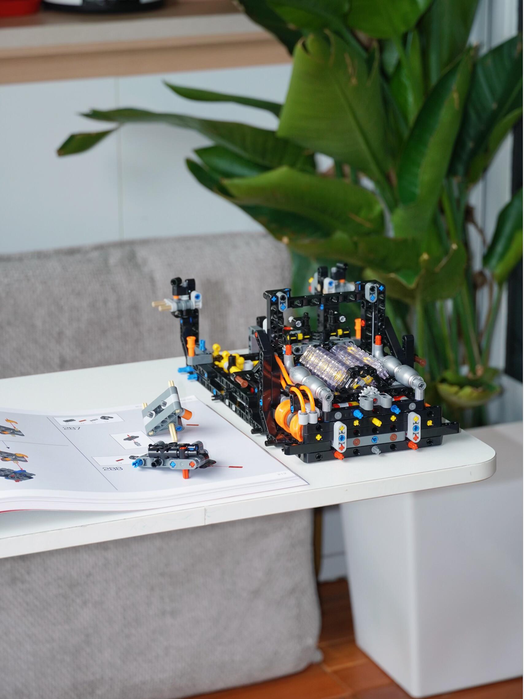 V8 engine subassembly with open manual on a sunny balcony desk